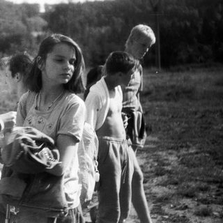 Children playing outdoors in a rural field.
