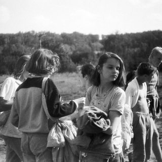 Children playing outdoors in a rural field.