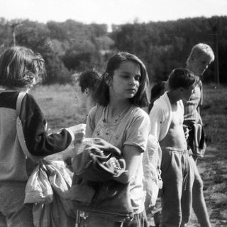 Children playing outdoors in a rural field.