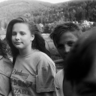 Three people standing outdoors by water.