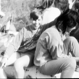 Group of people sitting outdoors, engaged in conversation.