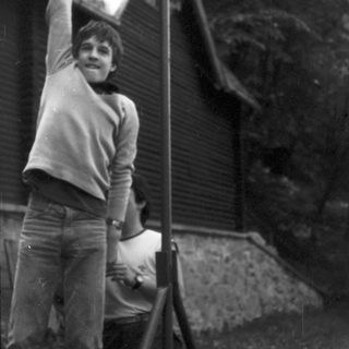 Young man climbing outdoor rock wall.