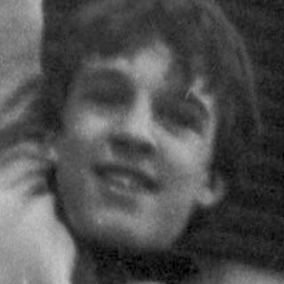 Young person climbing or hanging from a pole.