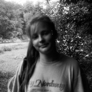 Blurry black-and-white photo of smiling person outdoors.