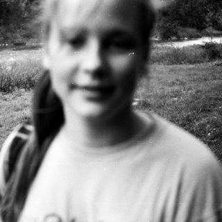 Blurry black-and-white photo of smiling person outdoors.