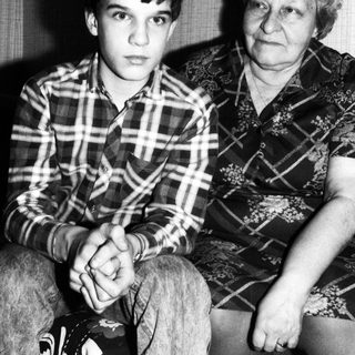 Two generations sitting indoors, grandmother and grandson.