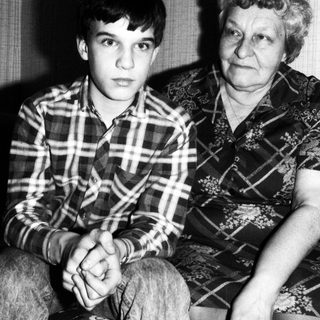 Two generations sitting indoors, grandmother and grandson.