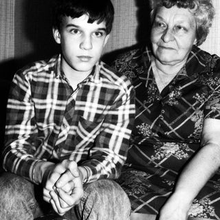 Two generations sitting indoors, grandmother and grandson.