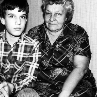 Two individuals, likely grandmother and grandson, posing together.