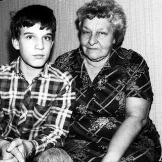 Two individuals, likely grandmother and grandson, posing together.