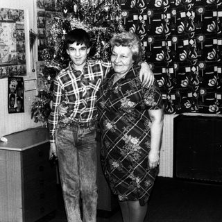 A man and woman posing together indoors, likely in the 1970s or 1980s.