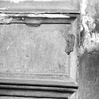 Damaged architectural stone corner with cracks.
