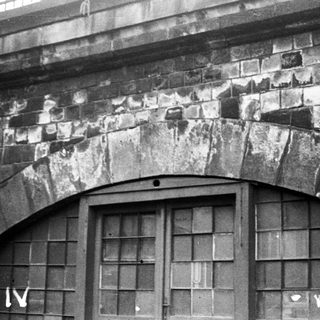 Architectural stone archway with weathered bricks.