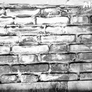 Weathered brick wall with visible cracks and erosion.