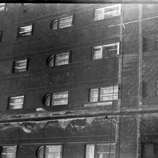 Damaged multi-story building facade with broken windows.
