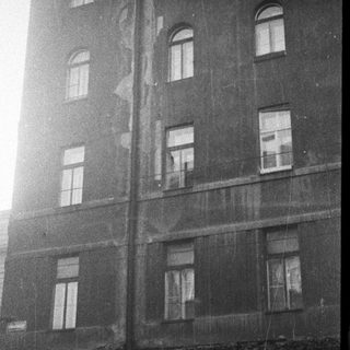 Multi-story building exterior with aged windows.