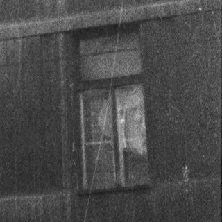 Multi-story building exterior with aged windows.