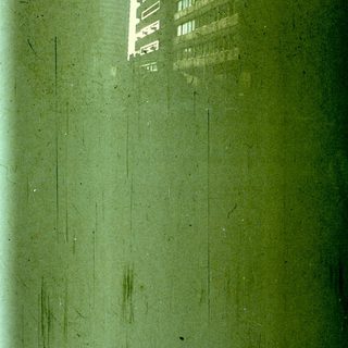 Reflection of tall buildings in wet pavement.