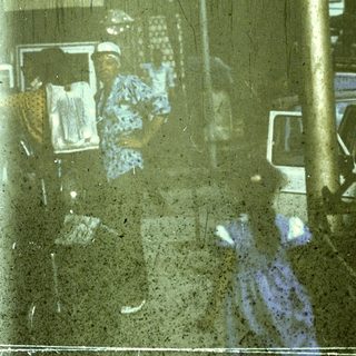 Flooded street with reflections of people and vehicles.