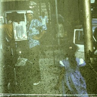 Flooded street with reflections of people and vehicles.