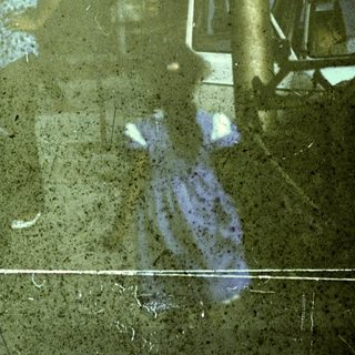Flooded street with reflections of people and vehicles.