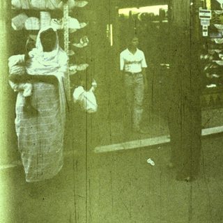 Reflection of people walking with shopping bags.