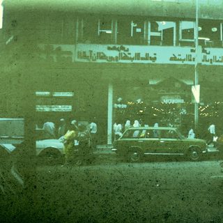 Busy urban street scene with Arabic signage.