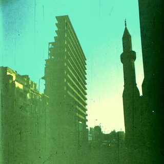 Urban skyline with modern buildings and mosque minaret.