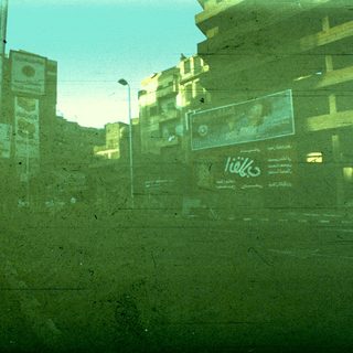 Urban street scene with blurred reflections of signs.