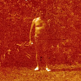 Person dancing alone in grassy outdoor area.