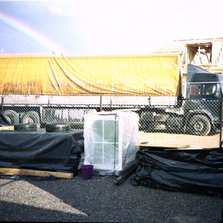 Construction site with covered truck and storage containers.