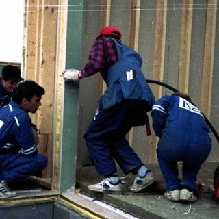 Construction workers installing wooden framing on site.