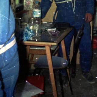 Indoor scene with three men in work uniforms.