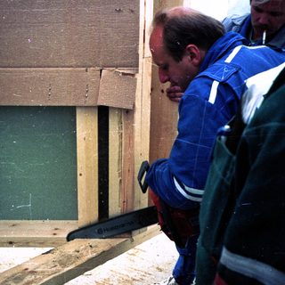 Workers cutting into a damaged wall.
