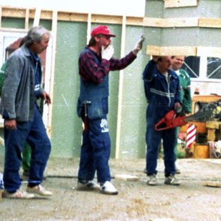 Construction crew building a two-story house frame.