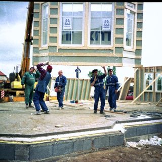 Construction workers assembling wooden frame structure.