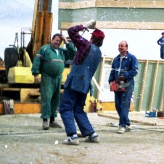 Construction workers assembling wooden frame structure.