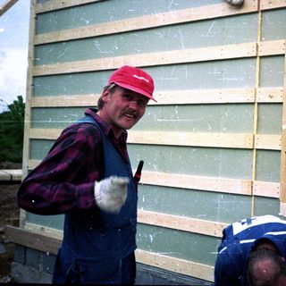 Workers installing siding on a building.