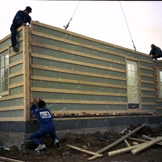Construction workers assembling prefabricated building panels.