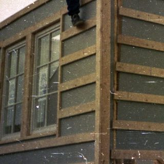Construction workers installing exterior siding on a house.