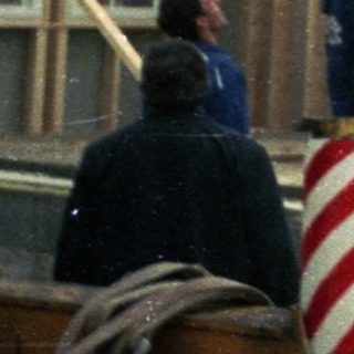 Construction workers assembling wooden house frame.