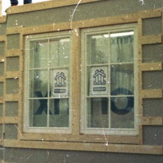Construction workers assembling wooden house frame.
