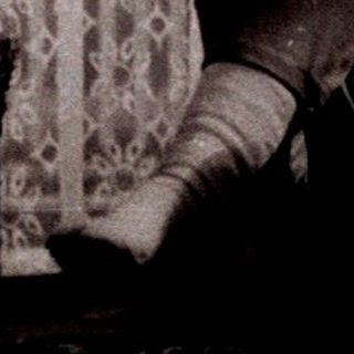 Child reading on bed near window.