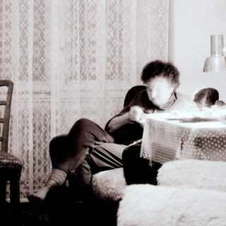 Child reading on bed near window.