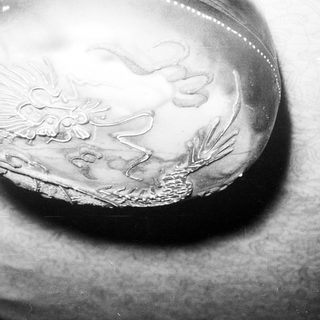 Engraved silver plate featuring Chinese dragon design.