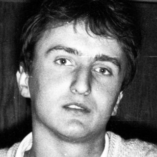 Young man indoors, looking surprised.