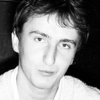 Young man indoors wearing a light sweater.