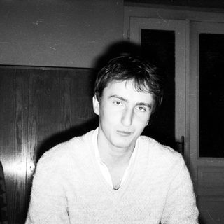 Young man indoors wearing a light sweater.