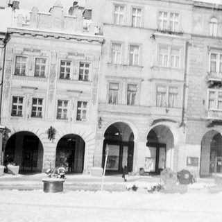 Historic European street with multi-story buildings and arches.