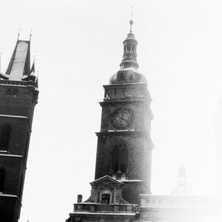 Historic clock tower with adjacent church spire.